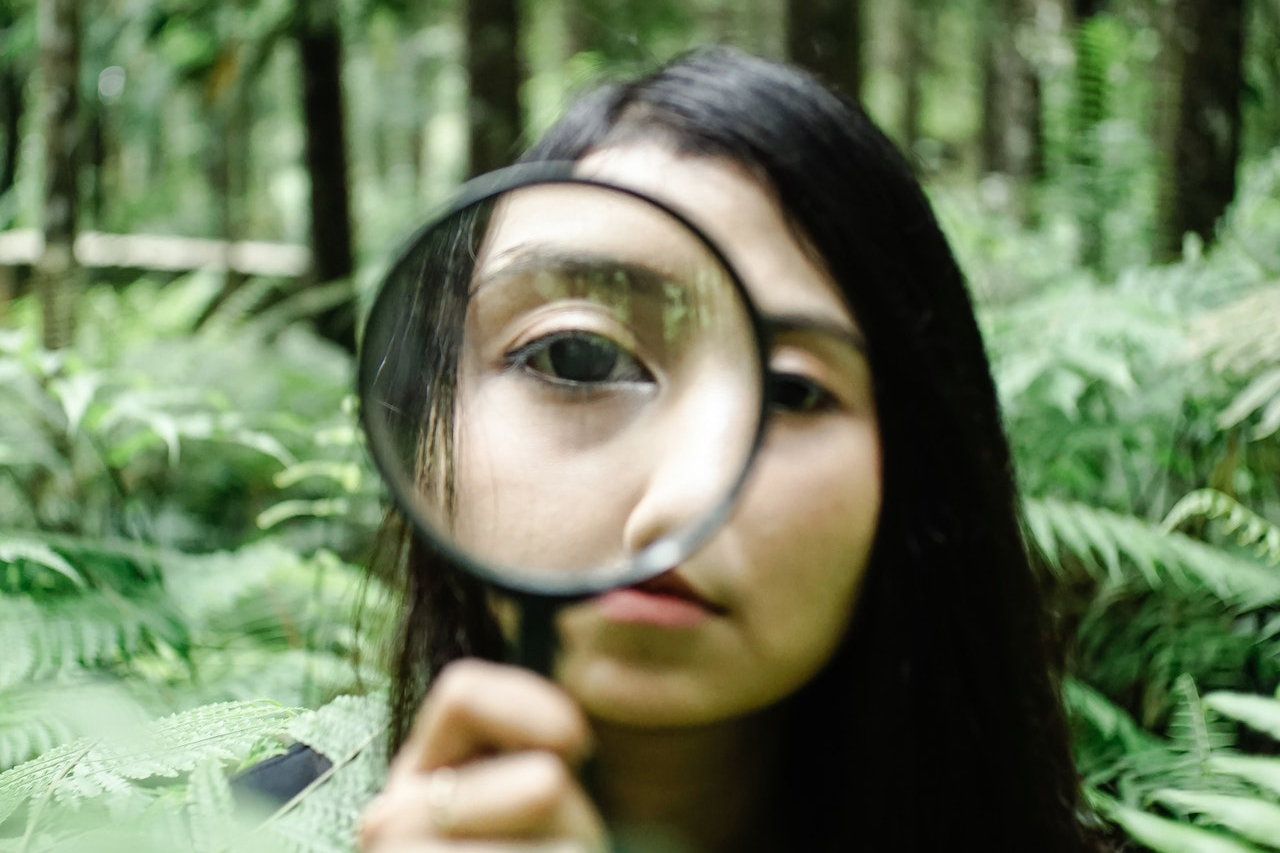 image of woman looking through magnifying glass