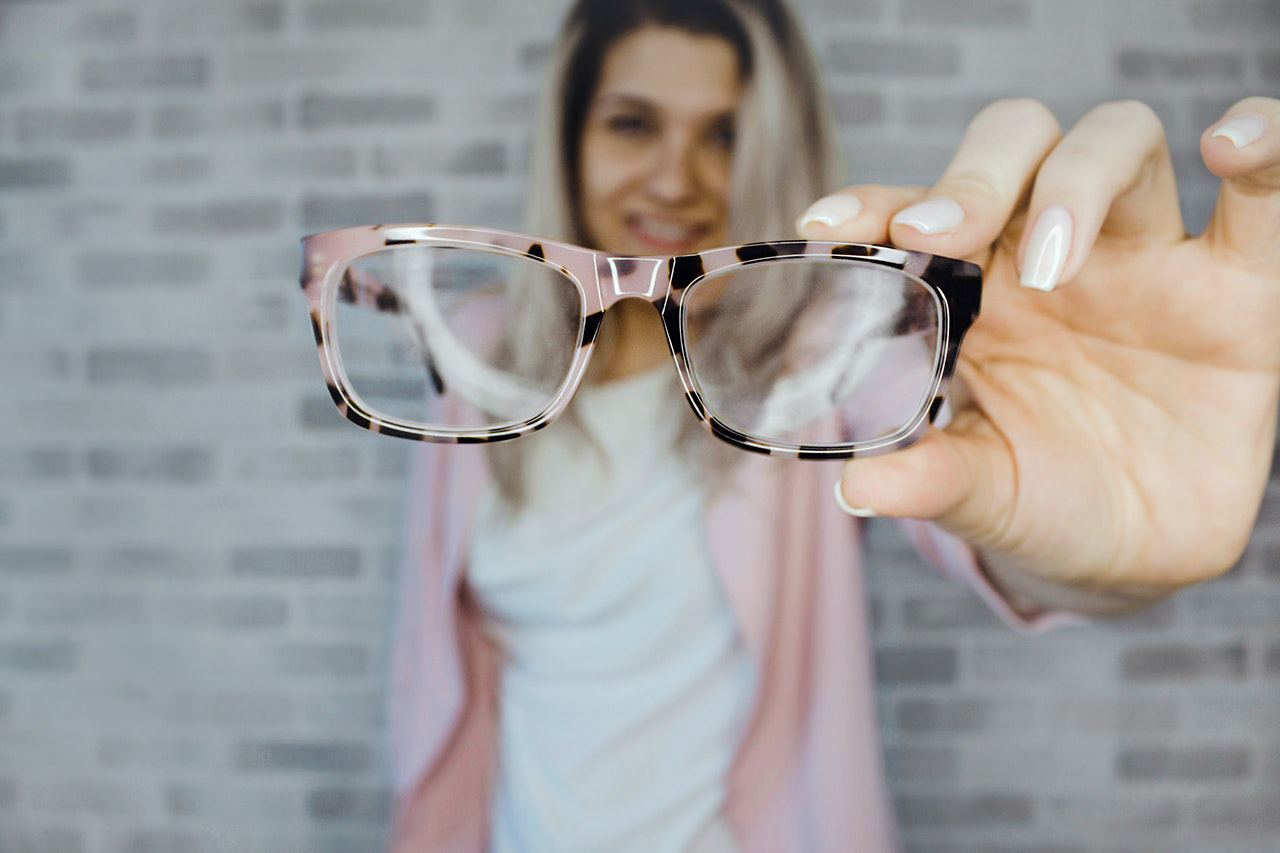 image of woman holding eye glasses