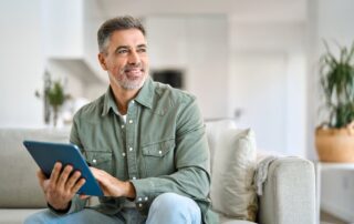middle-aged-man-happy-reading-on-his-tablet-without-glasses