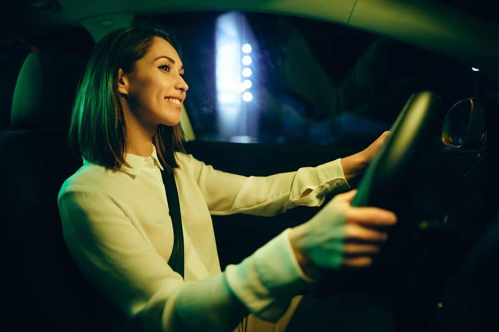 young-woman-driving-happy-at-night
